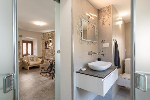 ein Bad mit einem Waschbecken und einem WC in einem Zimmer in der Unterkunft Apartman Stefani in Krk
