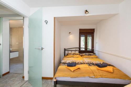 a bedroom with a bed and a glass wall at Apartman Stefani in Krk