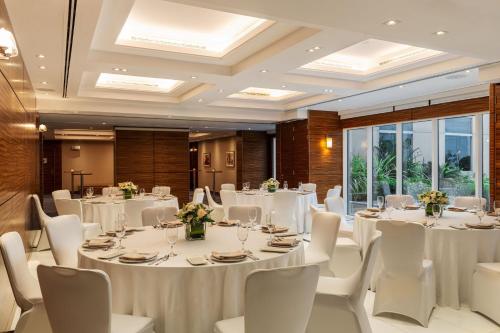 a conference room with white tables and chairs and windows at Four Points by Sheraton Bur Dubai in Dubai