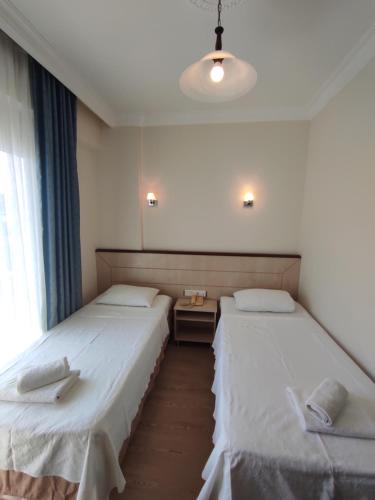 two beds in a small room with at AYHAN OTEL in Cesme