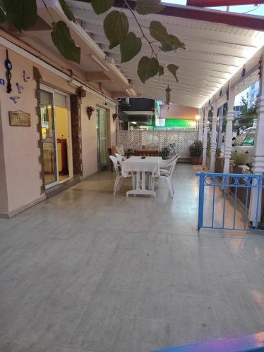 a patio with a table and chairs in a building at AYHAN OTEL in Cesme