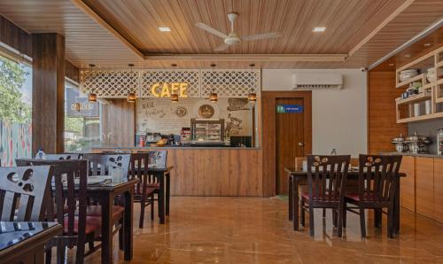 a restaurant with wooden tables and chairs and a counter at Treebo Seven Olives in Mumbai