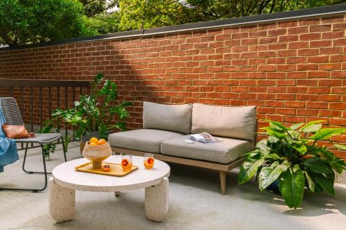 kanapę siedzącą na patio obok ściany z cegły w obiekcie Sonder Georgetown C&O w Waszyngtonie