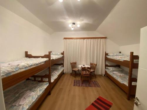 a room with three bunk beds and a table at Guesthouse GS 84326 in Gusinje