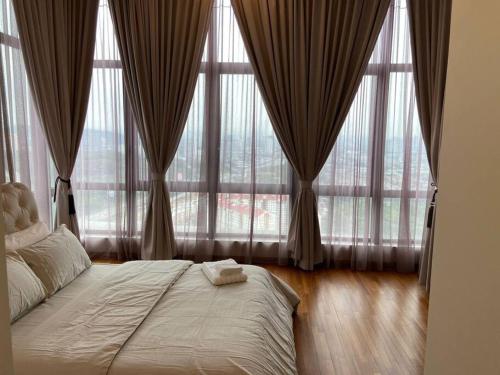 a bedroom with large windows and a bed in front at Tropicana Grande Luxurious Stay in Kota Damansara