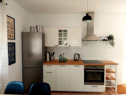 a kitchen with white cabinets and a stainless steel refrigerator at Ruralna kuća za odmor Julijana in Štrigova