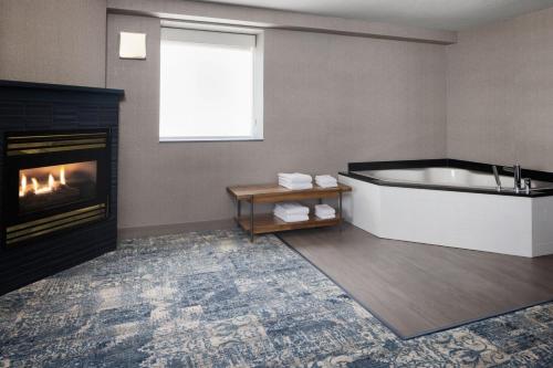 a bathroom with a tub and a fireplace at Four Points by Sheraton Edmonton South in Edmonton