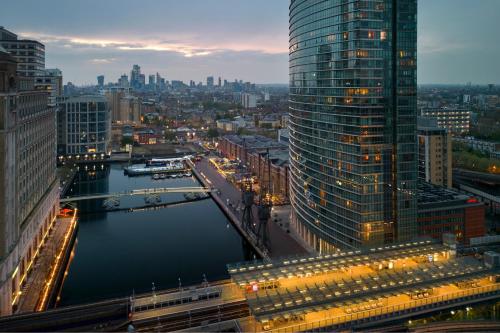 London Marriott Hotel Canary Wharf في لندن: اطلالة على مدينة بها نهر ومباني