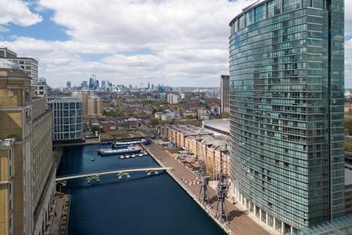 ロンドンにあるLondon Marriott Hotel Canary Wharfの川と建物のある街のアリアルビュー