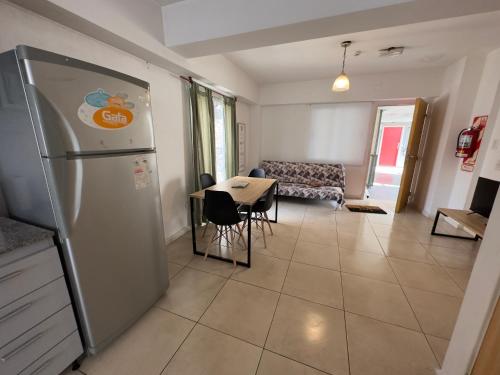cocina y sala de estar con refrigerador y mesa en Depto Malbec calle Cordoba en Mendoza