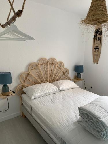 - une chambre avec un lit avec une tête de lit en bois et deux lampes dans l'établissement 2 pièces 2 pas des plages, à Saint-Palais-sur-Mer
