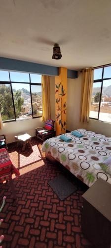 a bedroom with a large bed in a room with windows at Suma Uta in Copacabana