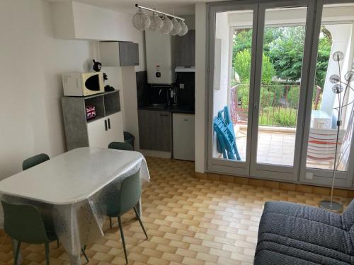 une cuisine et un salon avec une table et des chaises dans l'établissement Studio Cabine Clim Wifi Parking Draps - 1 étoile - self check-in possible, à La Grande Motte
