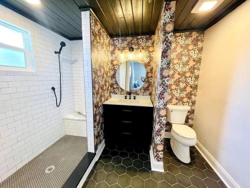 a bathroom with a toilet and a sink and a mirror at Luxury - Pet Friendly, Farmhouse Bungalow DT Tampa in Tampa