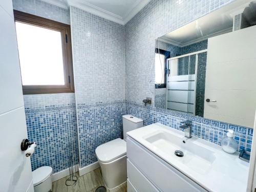 y baño con lavabo, aseo y espejo. en OleHolidays Cancelas centro ciudad, en Marbella