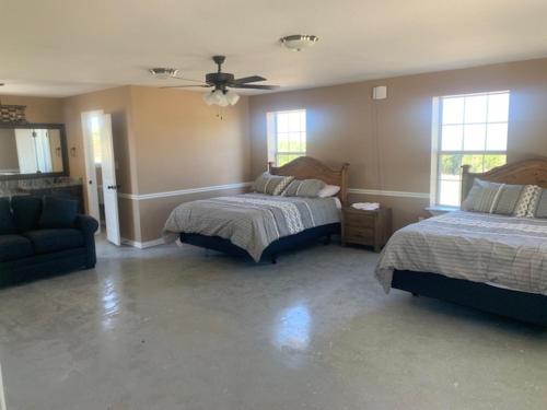 a bedroom with two beds and a blue couch at Hitching Post in Springtown