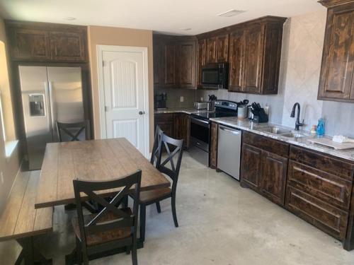 a kitchen with wooden cabinets and a table and chairs at Hitching Post in Springtown