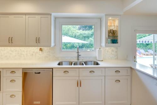 a kitchen with white cabinets and a sink and a window at Luxurious Bloomfield Hills Oasis with Pool and Spa! in Bloomfield Hills