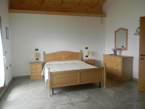 a bedroom with a bed and two dressers and a mirror at Agritur Vista Lago in Revò