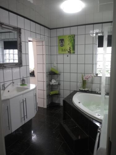 a bathroom with a tub and a sink at FeWo Blaue Oase, Netflix, Massagesessel, Whirlpool Badewanne in Germersheim