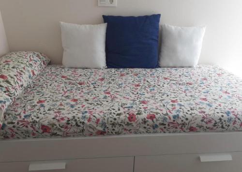 a bed with a floral comforter and two pillows at Centro Lugo in Lugo