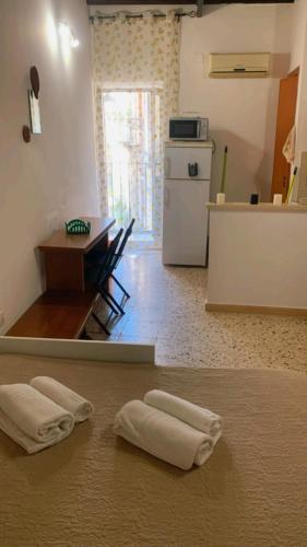 a kitchen with a table and two towels on the floor at Civico 53 in Siracusa