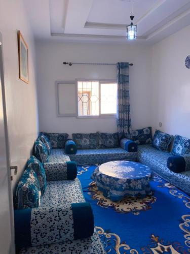 a living room with blue couches and a table at Panorama guest house in Sidi Ifni