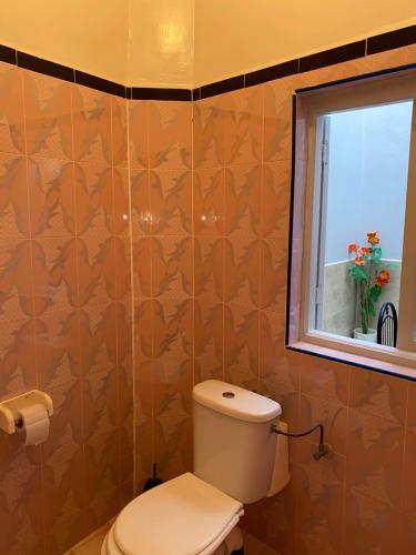 a bathroom with a toilet and a window at Panorama guest house in Sidi Ifni
