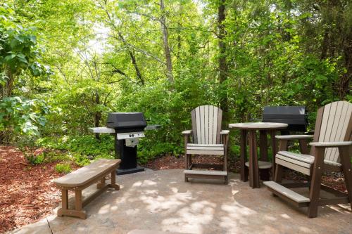 a grill and two chairs and a table with a bench at Marriott's Willow Ridge Lodge in Branson