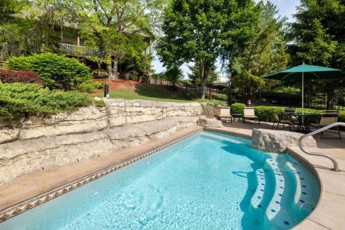 a swimming pool with an umbrella in a yard at Marriott's Willow Ridge Lodge in Branson