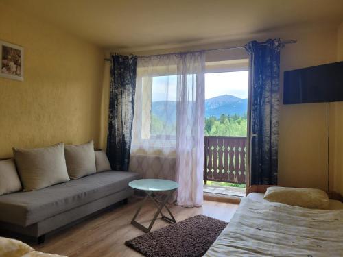 a living room with a couch and a large window at Stropnica in Karpacz