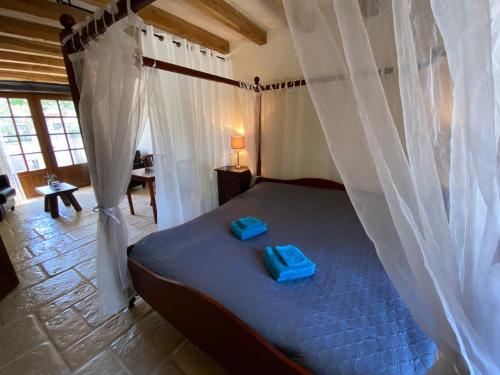 Un dormitorio con una cama con toallas azules. en DomaineRossignol Lavande, en Gourdon-en-quercy
