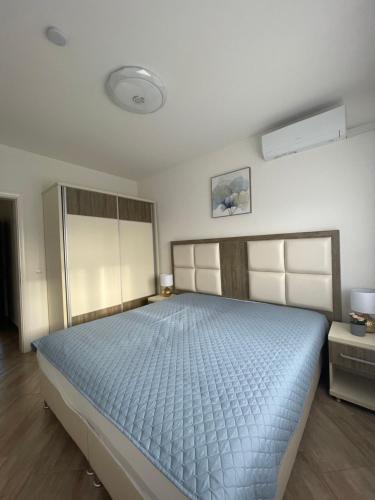 a bedroom with a large bed with a blue comforter at Villa Sunshine in Bar
