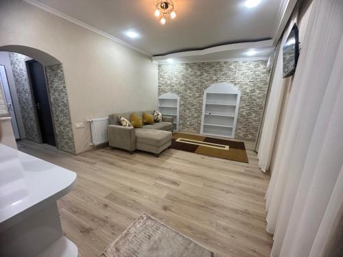 Una sala de estar con un sofá y una pared de piedra. en Giorgi Apartment, en Tiflis