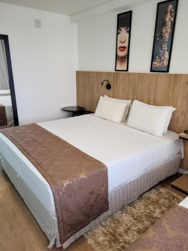 a bedroom with a large bed with a wooden headboard at Transamerica Executive Maringá in Maringá