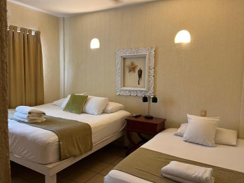 a hotel room with two beds and a mirror at CENTRO, CERCA ToDo in Cancún