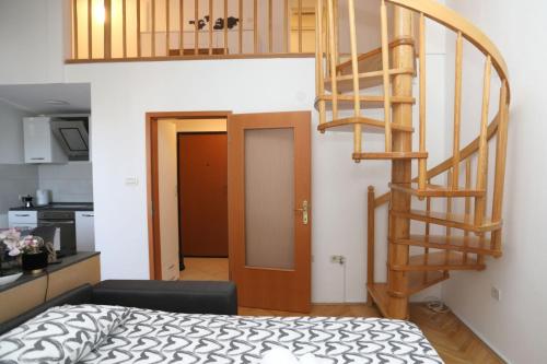 普萊曼圖拉的住宿－Apartman Cinkopan Premantura 1，一间设有螺旋楼梯的房间和一间卧室