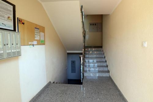 a hallway with stairs in a building with a blue door at Apartman Cinkopan Premantura 1 in Premantura