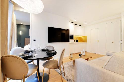- un salon avec une table à manger et un canapé dans l'établissement Elegant apartment - 2BR 6P - Opéra, à Paris