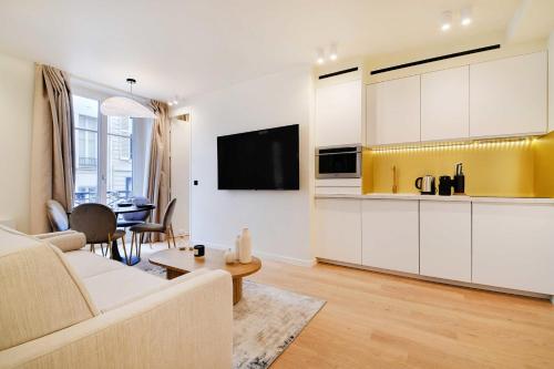 un salon avec un canapé et une cuisine dans l'établissement Elegant apartment - 2BR 6P - Opéra, à Paris
