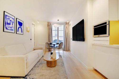 un salon avec un canapé blanc et une table dans l'établissement Elegant apartment - 2BR 6P - Opéra, à Paris