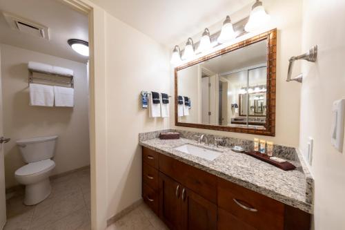 a bathroom with a sink and a toilet and a mirror at Hanalei Bay Resort in Princeville