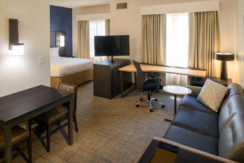um quarto de hotel com um sofá, uma secretária e uma cama em Residence Inn Columbia Northeast/Fort Jackson Area em Columbia