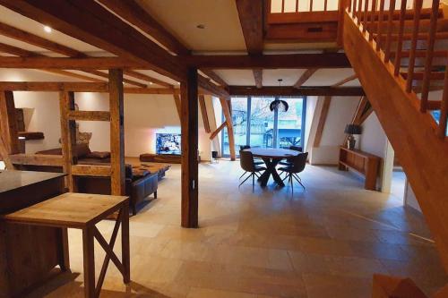 Habitación grande con escalera de madera y mesa. en Apartment Luna, en Creglingen