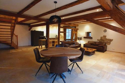 una gran sala de estar con mesa de madera y sillas. en Apartment Luna, en Creglingen