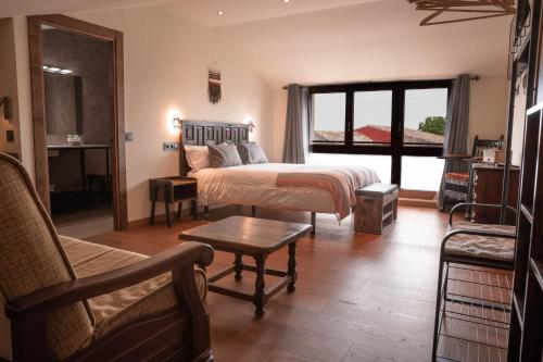 a bedroom with a bed and a couch and a chair at HOTEL POSADA LaS RETAJAS in Medinaceli