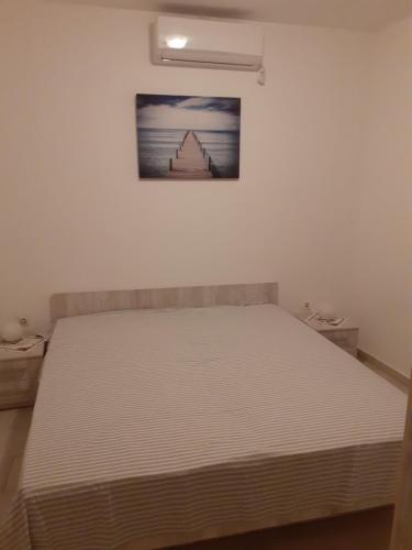- un lit dans une chambre avec une photo sur le mur dans l'établissement Apartmani Vlaho, à Molunat