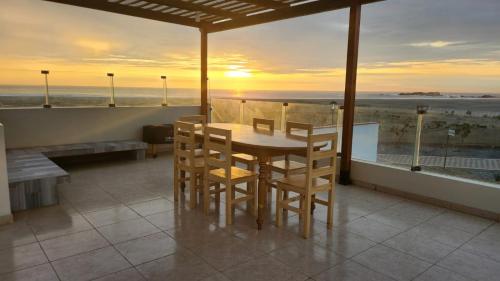 un tavolo e sedie su un balcone con vista sull'oceano di ALQUILER CASA DE PLAYA FRENTE AL MAR / “CONDOMIO CASTILLO DE ARENA”-HUARMEY 