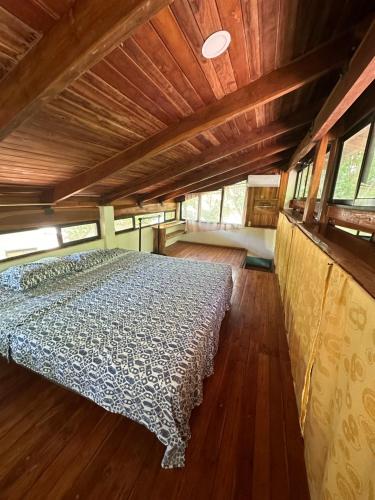 Una cama en medio de una habitación en una cabaña en Aldos place, en Playa Negra