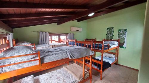 a bedroom with three bunk beds in a room at Nuna Hostel Floripa in Florianópolis